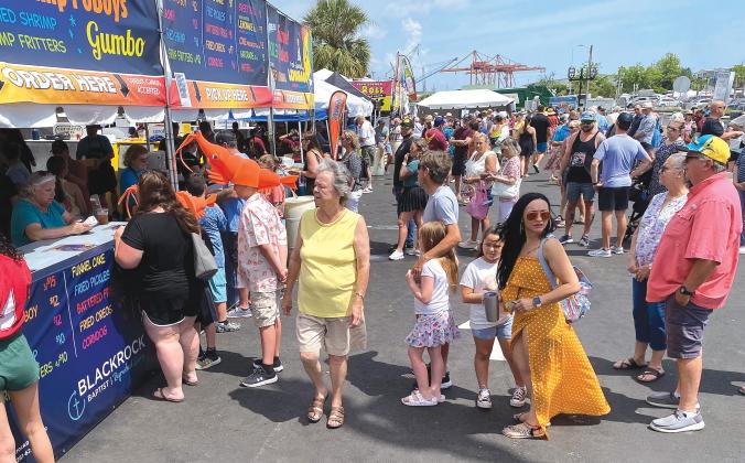 Visitors enjoy the vendors Saturday morning at the 60th anniversary Isle of Eight Flags Shrimp Festival. Photo by Beth Jones/News-Leader