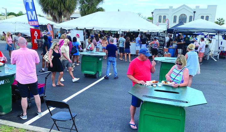 Visitors enjoy the vendors Saturday morning at the 60th anniversary Isle of Eight Flags Shrimp Festival. Photo by Beth Jones/News-Leader