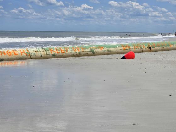 Pictured May 30, writing on the pipe located at Main Beach cautions beachgoers to “keep off” and “do not cross.” Photo by Julia Roberts/News-Leader
