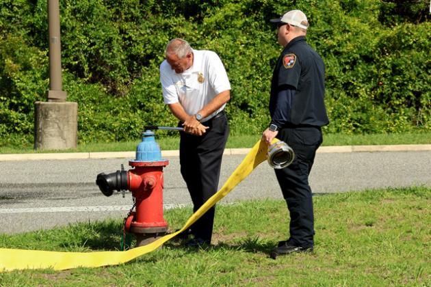 Nassau County Fire Rescue Chief Brady Rigdon taps into the water supply from the hydrant while Lt. Jeremy Roberts holds the hose connected to the fire truck.  (ANNA NEWHOFF/Nassau County Record)