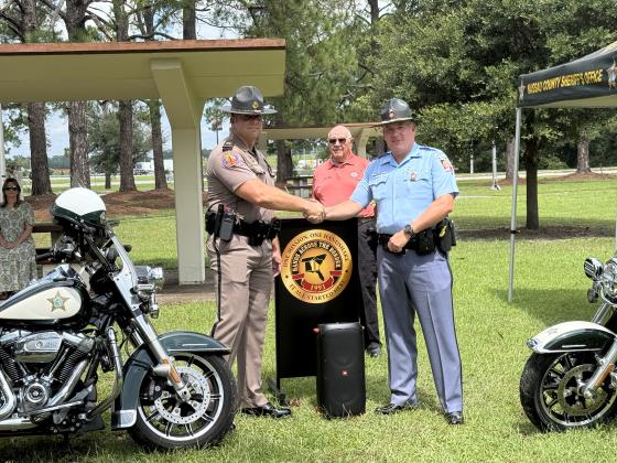 Florida Highway Patrol Capt. Aaron Stephens and Georgia Highway Patrol Sgt. Dan Chernich shake hands at Hands Across the Border Wednesday. Georgia Governor's Office of Highway Safety Capt. Luther Hires stands in the background.
