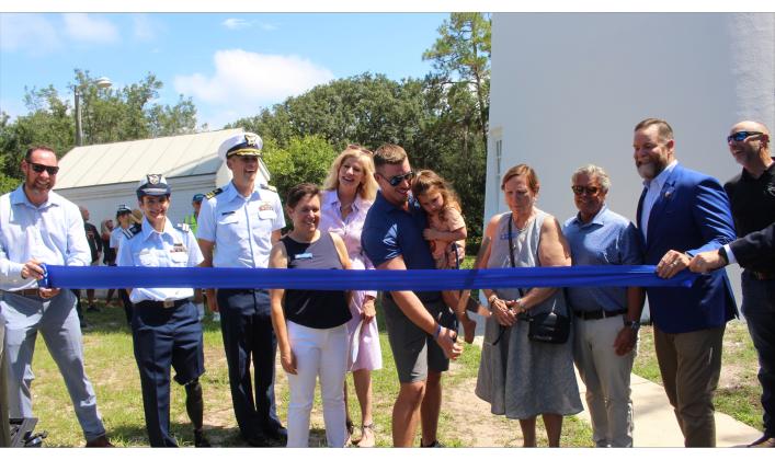 Mayor James Antun and his daughter cut the ceremonial ribbon. Also pictured, commissioners Joyce M Tuten, Genece Minshew, Tim Poynter, Congressmen Aaron Bean, Jeremiah Glission, and members of the Coast Guard. Photo by Marisa DeMar/News-Leader