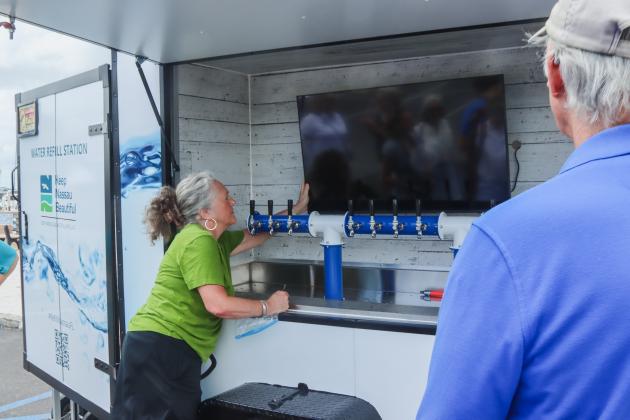 Lynda Bell, executive director of Keep Nassau Beautiful, shows off the new water cart. Photo by Ashley Chandler/News-Leader