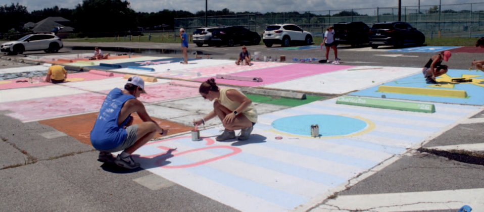 Seniors Charleston Knight and Ian Miller paint their parking spot days before the start of the school year. Photo by Marisa DeMar/New-Leader