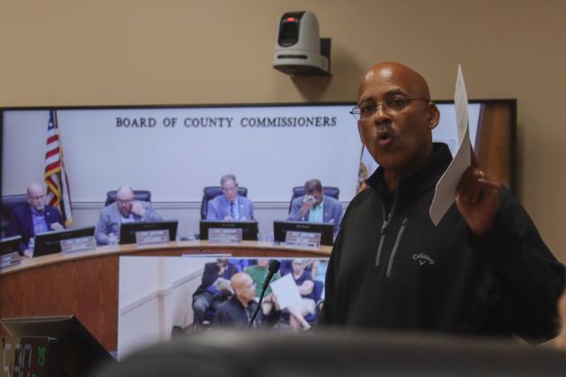 President of Save Historic American Beach Inc. Mark Dawkins holds up the Nassau County Protected Species Management Plan at the Aug. 11 Board of County Commissioners meeting. Photo by Ashley Chandler/News-Leader