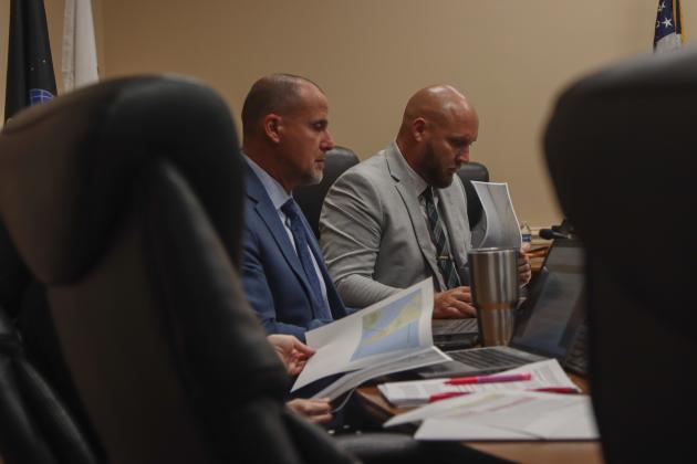 From left, Assistant County Manager Marshall Eyerman and County Manager Taco Pope look over maps presented by President of Save Historic American Beach Inc. Mark Dawkins at the Aug. 11 Board of County Commissioners meeting. Photo by Ashley Chandler/News-Leader