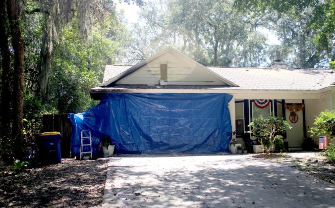 Above, The Heritage family home is covered by a tarp Wednesday on the side of the house that was most damaged after a lightning strike started a fire in the attic Tuesday. Photo by Marisa DeMar/News-Leader