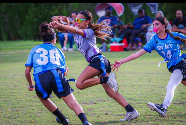 Kyndall Whitley, Soraya Burgos and Jade Fisher. Whitley has the ball, chased by Burgos and Fisher.