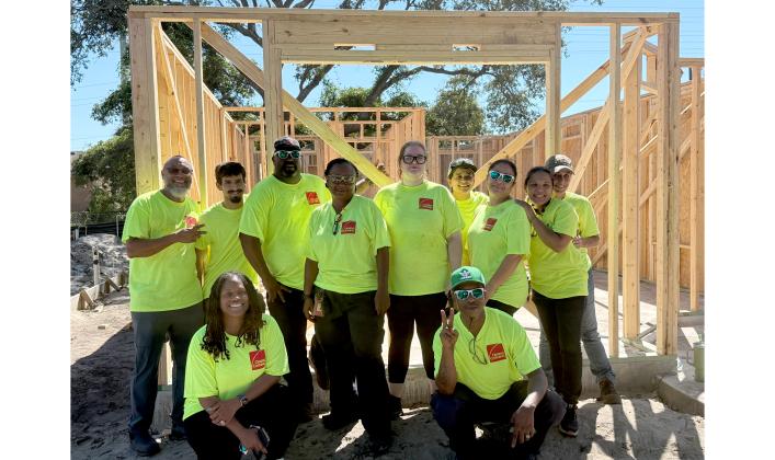 Owens Corning employees stand by the framing of a Habitat for Humanity home they worked on Friday, Sept. 5. Nick Blank/News-Leader