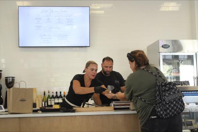 Greg and Jess Devaney serving a customer at Marché Côtier on their opening day, Sept. 3.  By Marisa DeMar/News-Leader 