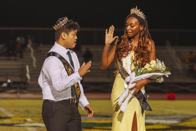 Yulee High School Homecoming King Rodel Bagnes and Queen Myka Gray high five after being crowned during halftime of the Hornets football game Friday. Photo by Ashley Chandler/News-Leader