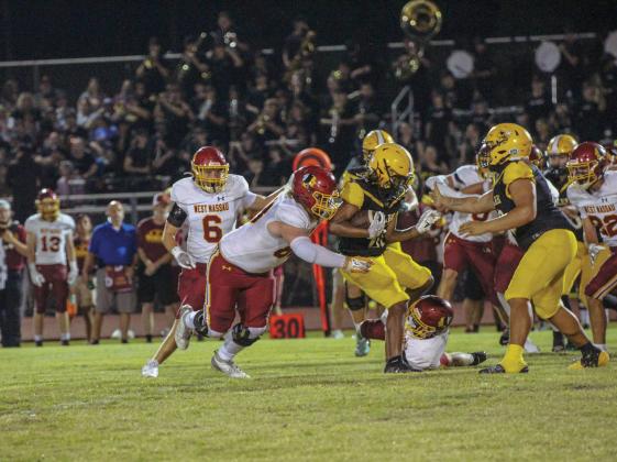 Hornets Running Back Shamar Gibbs makes the run amidst pressure from the Warriors defense By Marisa DeMar/News-Leader