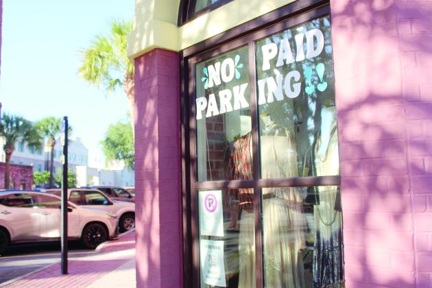 Marisa DeMar/News-Leader  A No Paid Parking sign and QR code to the citizen petition placed on the corner of a shop window in downtown Fernandina Beach on Tuesday.