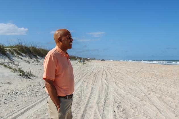 President of Save Historic American Beach Mark Dawkins stands in tire tracks out on the beach earlier this year in American Beach. Ashley Chandler/News-Leader