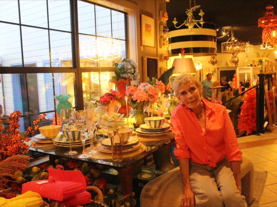 Store owner Linda Hall poses in front of her colorful table settings for sale at Chacato on Wednesday.