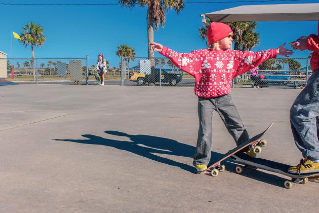 Goldie Waldo grabs a snack from her sister Tuesday at the Poe Pinson Skate Park. Photo by Marisa DeMar/News-Leader