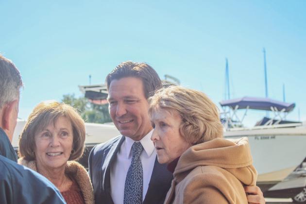 The governor poses for photos after his news conference in Fernandina Beach on Monday.