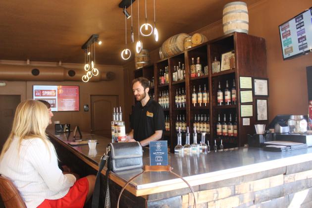 Walker Lee serves customers a taste of their house-made liquors at Marlin &amp; Barrel tasting room on Oct. 30.