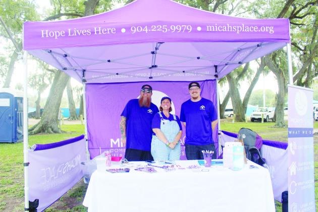 Micah's Place board members Tracie Fasel, Robby Whitley, Chaz Skarpalezos at their tent on Community Care Day on Saturday.  By Marisa DeMar/News-Leader