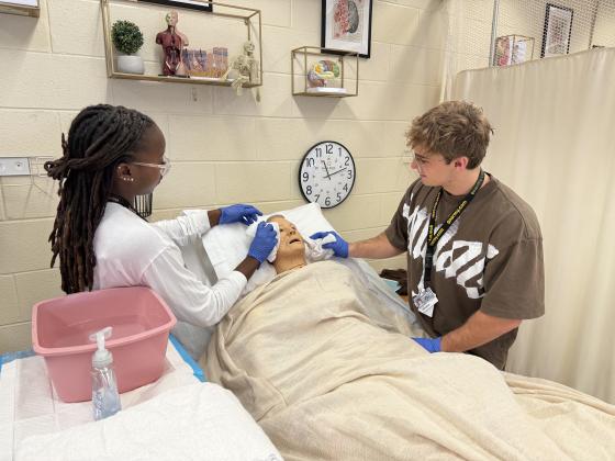 Students Passion Roberts and Myo Magyari practice on a mannequin. Photo by Nick Blank/News-Leader