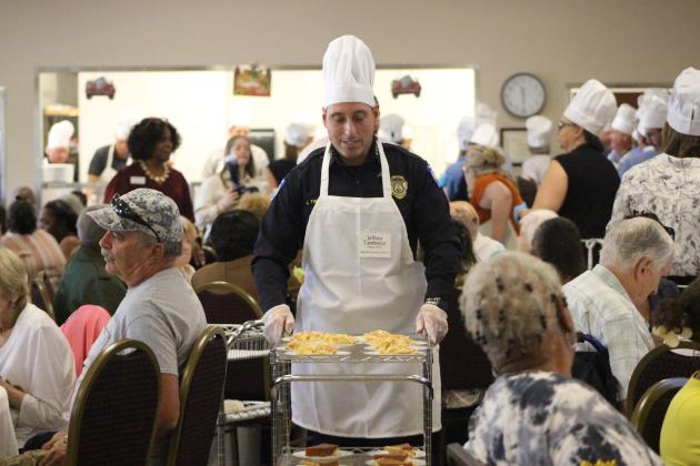 Jeff Tambasco, Fernandina Beach Police Chief serves pies at the NCCOA Thanksgiving Luncheon. By Marisa DeMar/News-Leader  