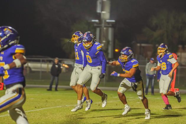 Pirates defensive end Kalani Tucker, 0, and teammates celebrate a pick-6 against the Bell High Bulldogs. Photo by Ashley Chandler/News-Leader