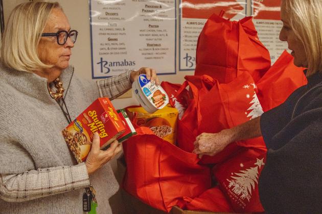 President and CEO of Barnabas Center, Jamie Reynolds, left, shows some donated food items to Anne Gower, co-chair of the Campaign Committee, on Monday at Barnabas Center. Photo by Ashley Chandler/News-Leader