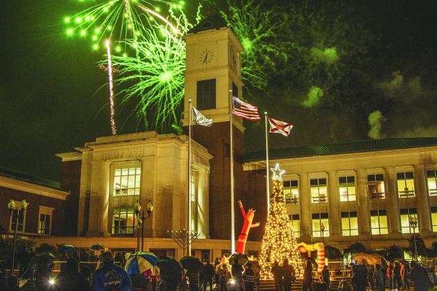Attendees of the Nassau County tree lighting event Friday watch the fireworks that followed the lighting from under umbrellas at the Robert M. Foster Justice Center in Yulee. Photo by Ashley Chandler/News-Leader