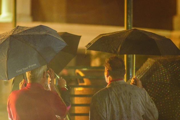 Commissioners A.M. “Hupp” Huppmann and Jeff Gray watch the fireworks under umbrellas Friday at the county’s tree lighitng event. Below, rain dumps on the Kid’s Zone at the county’s tree lighting event. Photo by Ashley Chandler/News-Leader