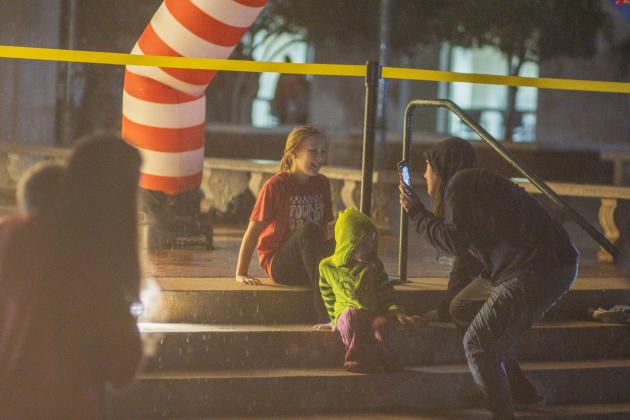Attendees of the Nassau County tree lighting event Friday watch the fireworks that followed the lighting from under umbrellas at the Robert M. Foster Justice Center in Yulee. Photo by Ashley Chandler/News-Leader