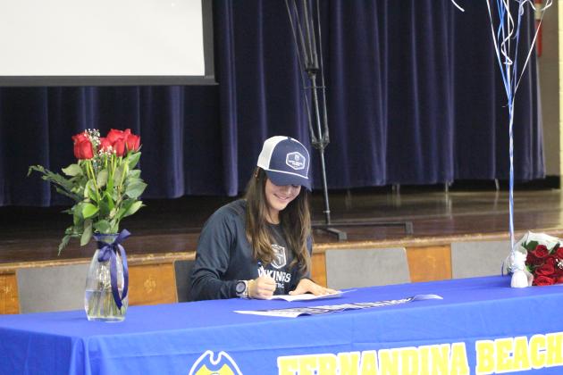 Grace Scuderi signs her letter of comittment to persue cross country at Berry College in Georgia. By Marisa DeMar/News-Leader
