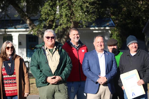 City officials pose next to the new Holly trees at the Peck Center Field. By Marisa DeMar/News-Leader