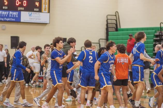 Fernandina Beach High School students and varsity basketball players celebrate in the Yulee High School gymnasium after the Pirates beat the Hornets by two points on Friday. Photo by Ashley Chandler/News-Leader