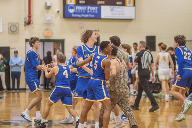 Fernandina Beach High School students and varsity basketball players celebrate in the Yulee High School gymnasium after the Pirates beat the Hornets by two points on Friday. Photo by Ashley Chandler/News-Leader