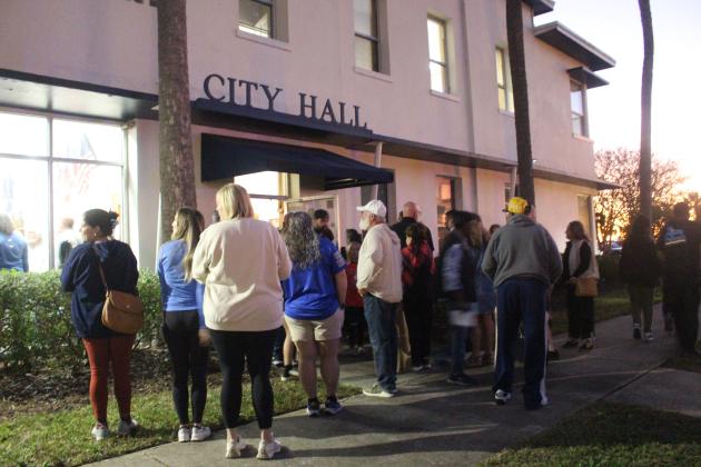Attendees of a previous Fernandina Beach City Commission meeting congregate outside City Hall ahead of the meeting. Photo by Marisa DeMar/News-Leader