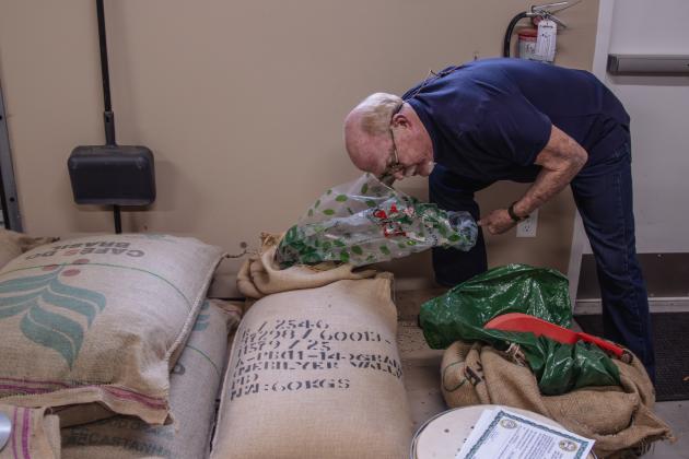 Gil Johnston gets raw beans out of the bags shipped from suppliers.
