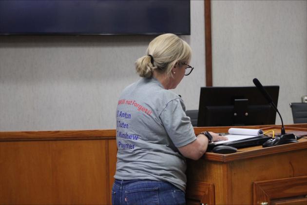 Andrea Lee wears a shirt expressing her disapproval of the four commissioners that voted for paid parking as she addresses them at the city meeting.  By Marisa DeMar/News-Leader