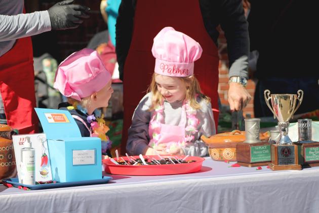 Local kids help in serving chili with their family. By Marisa DeMar