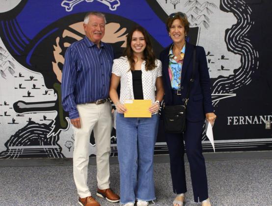 Fernandina Beach High School's Anna Ross, a 2025 scholarship winner, stands with I4E founder John Elwell and board member Claudia Watts.