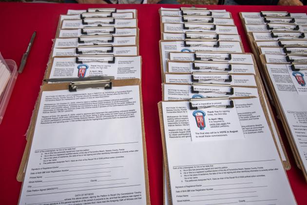 Petitions aligned on the table of Recall FB 2026 farmers market booth at the mid-week farmers market on 14th and Lime. Marisa DeMar/News-Leader