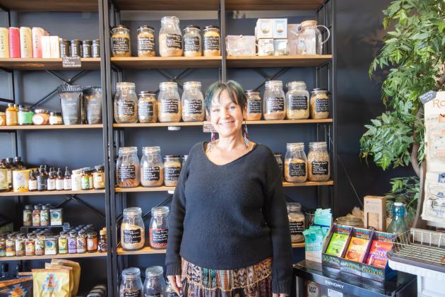 Jill Vozza, the owner of Sand and Sage Mystic Shoppe, stands in front of the wall of herbal teas at the store on Atlantic Avenue. Photo by Marisa DeMar/News-Leader