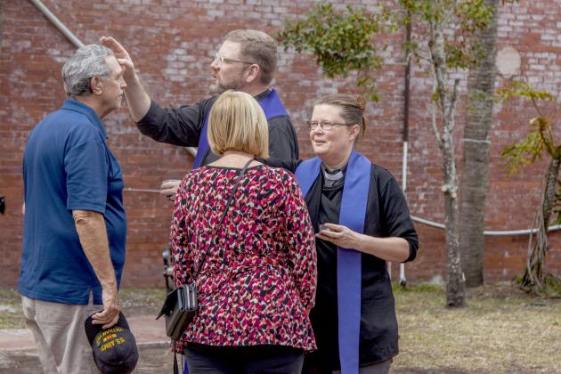 From left, the Rev. Dr. Mark Charles, senior pastor at Memorial United Methodist Church, and Mother Rachel McElwee, priest associate and children’s ministry coordinator of St. Peter’s Episcopal Church, apply the imposition of ashes at Pocket Park in downtown Fernandina Beach. Photo by Ashley Chandler/News-Leader
