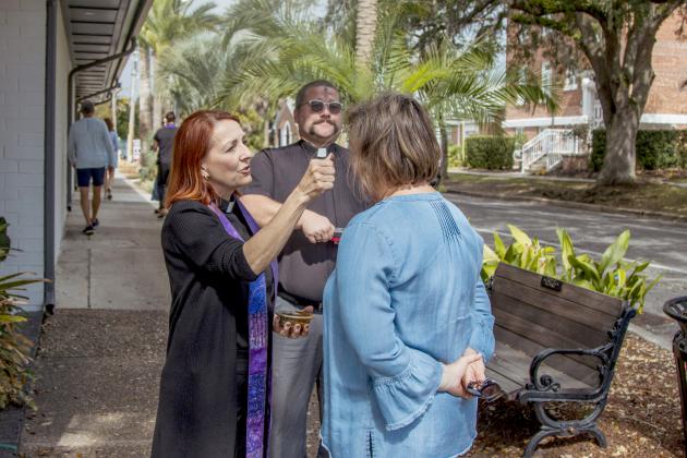The Rev. Dawn Mayes of First Presbyterian Church applies the imposition of ashes for someone passing by at the corner of 6th and Centre streets, as Pastor John Benjamin Mandrick of Prince of Peace Lutheran Church watches. Photo by Ashley Chandler/News-Leader