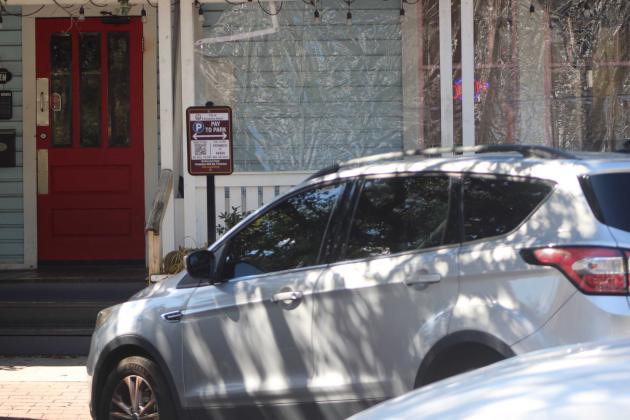 A car is parked in front of paid parking signage containing the QR code with directions to pay Monday afternoon in downtown Fernandina Beach. Marisa DeMar/News-Leader