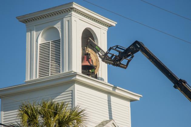 Workers from White’s Clock &amp; Carillon remove the bell from the belfry at First Presbyterian Church on 6th Street in downtown Fernandian Beach. The bell was first hung in 1859. Photo by Ashley Chandler/News-Leader
