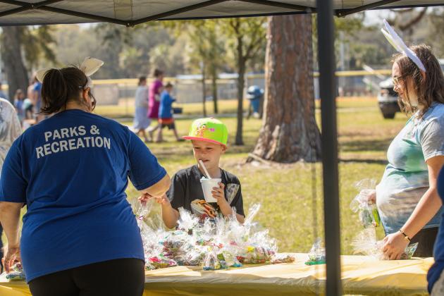 Lucinda Williams, left, of Fernandina Beach Parks and Recreation, hands out goodie bags at Fernandina Beach’s second annual Easter Egg Hunt. Photo by Ashley Chandler/News-Leader