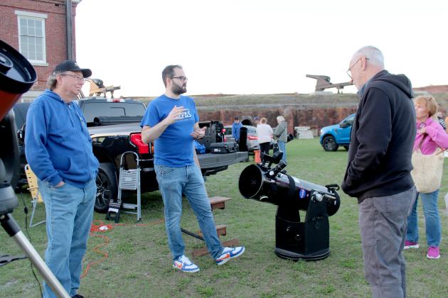 Zach Williams, president of the Northeast Florida Astronomical Society (middle) talks to an attendee of the Astronomy Night at Fort Clinch State Park. Photo by Amy Mulligan/News-Leader