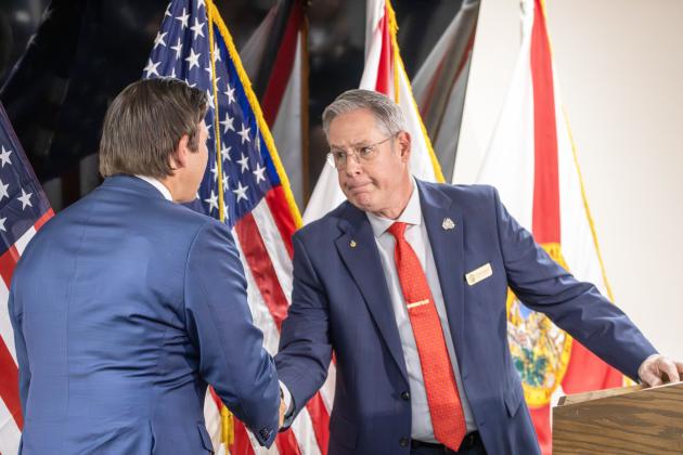 Nassau County Commissioner A.M. ‘Hupp’ Huppmann shakes hands with Gov. Ron DeSantis before speaking at a press conference Thursday at the James S. Page Governmental Complex.