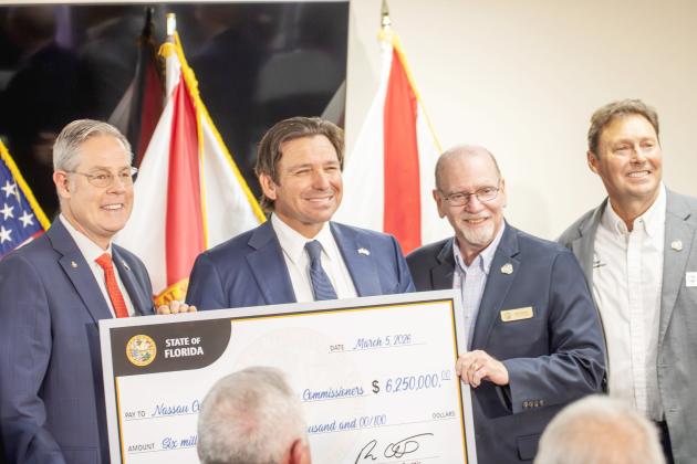 From left, Nassau County Commissioner A.M. ‘Hupp’ Huppmann, Gov. Ron DeSantis and commissioners John Martin and Jeff Gray with a ceremonial check for grant funds awarded to the county. Photo by Nick Blank/News-Leader