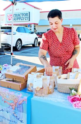 Cutline 1: Molly Vogel organizes sourdough breads and treats at her Doris & Eris Artisan Bakery stand at the Markets by Mariah farmers market at Tractor Supply on Saturday.  
